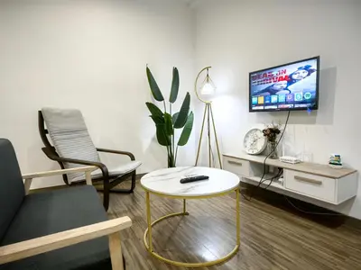 a living room with a couch and a table and a tv at Setapak Central Mall KL - Zetapark Garden Suites in Kuala Lumpur