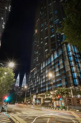 a city street at night with a large building at Eaton Residences by Sutera at KLCC in Kuala Lumpur