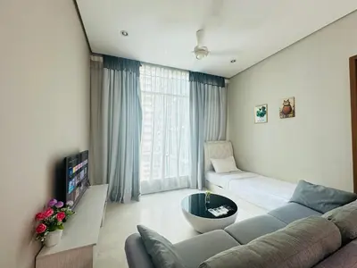 a living room with a couch and a large window at Soho Suites KLCC By Grand KL in Kuala Lumpur