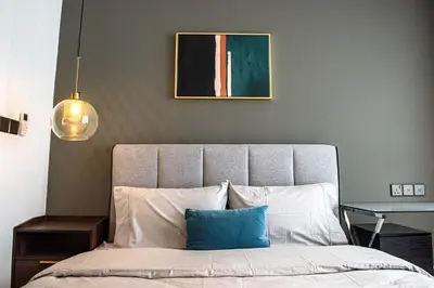 a bedroom with a bed with a picture on the wall at Stay @ NOVO Ampang in Kuala Lumpur