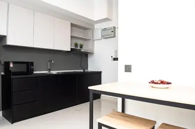 a kitchen with black and white cabinets and a counter at Stay @ NOVO Ampang in Kuala Lumpur