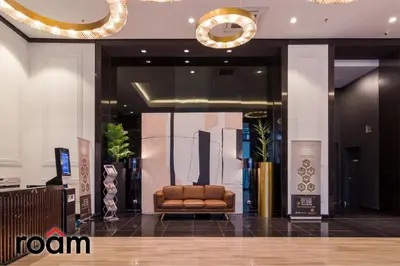 a lobby with a brown leather chair in a building at Chambers Residence, Sunway Putra Mall in Kuala Lumpur