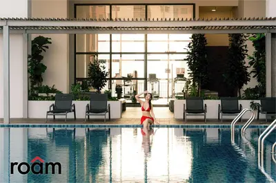 a woman standing next to a swimming pool at Chambers Residence, Sunway Putra Mall in Kuala Lumpur