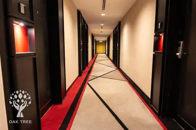 a long hallway with a red carpet and black doors at Red M101 by Oak Tree in Kuala Lumpur
