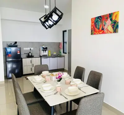 a dining room table with chairs and a kitchen at 4BR M Vertica near Sunway Velocity Cheras IKEA MRT TRX KLCC Pavilion in Kuala Lumpur