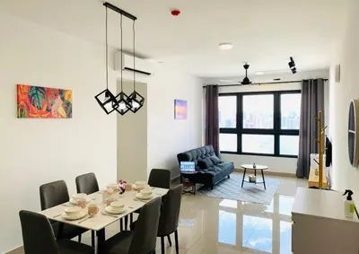 a dining room and living room with a table and chairs at 4BR M Vertica near Sunway Velocity Cheras IKEA MRT TRX KLCC Pavilion in Kuala Lumpur