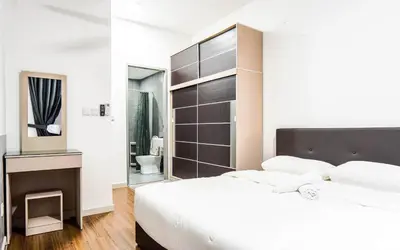 a bedroom with a large white bed and a bathroom at M Vertica KL by Airhost in Kuala Lumpur