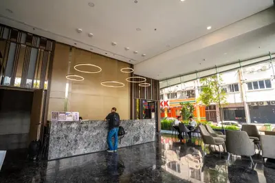 a man standing in the lobby of a building at Societe Suites By iHost Global in Kuala Lumpur