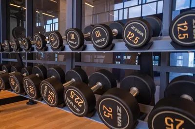 a bunch of dumbbells on display in a gym at Societe Suites By iHost Global in Kuala Lumpur