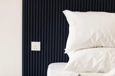 a bed with white pillows and a switch on a wall at Continew 1BR High TRX Mall King Bed 100Mbps Wi-Fi in Kuala Lumpur