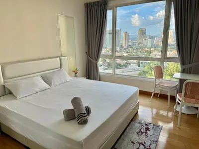 a bedroom with a white bed and a large window at HaBiBi hOmE Klcc in Kuala Lumpur