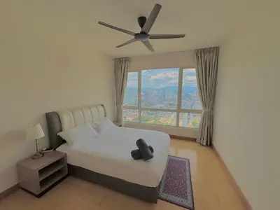 a bedroom with a bed with a ceiling fan and a window at HaBiBi hOmE Klcc in Kuala Lumpur