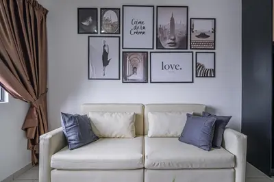 a living room with a white couch and pictures on the wall at Peaceful 2-bedroom for 6 Pax - Chan Sow Lin in Kuala Lumpur