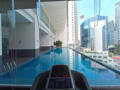 a remote control sitting next to a swimming pool in a building at RM201 Bukit Bintang 2 Bedroom Balcony CIty View in Kuala Lumpur
