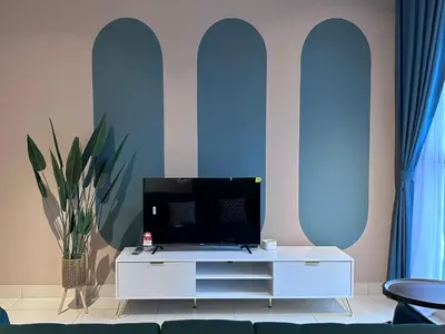 a living room with a tv on a white cabinet at KL Trion Residence near Velocity - IKEA - Lalaport - Bukit Bintang in Kuala Lumpur