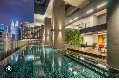 a swimming pool in the middle of a building at Klcc studio with a rooftop garden playground in Kuala Lumpur
