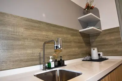 a kitchen with a sink and a wooden wall at The Play Suite@Pano. MRT. Free Parking. Self C/In in Kuala Lumpur