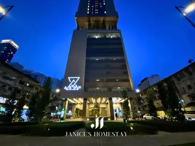 a building with a clock tower at night at Axon Residences Bukit Bintang by Janice's Homestay in Kuala Lumpur