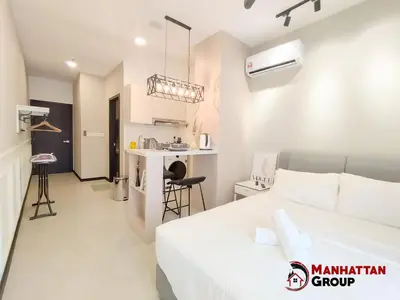 a bedroom with a bed and a kitchen in a room at Neu Suites By Manhattan Group in Kuala Lumpur
