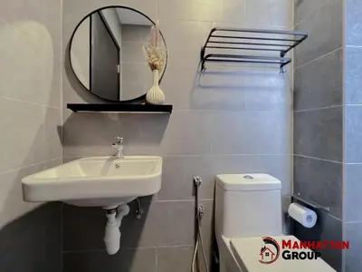 a bathroom with a sink and a mirror and a toilet at Neu Suites By Manhattan Group in Kuala Lumpur
