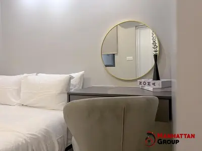 a bedroom with a mirror and a bed and a chair at Neu Suites By Manhattan Group in Kuala Lumpur