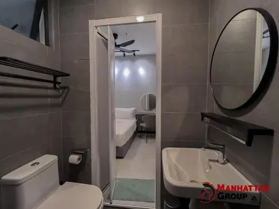 a bathroom with a toilet and a sink and a mirror at Neu Suites By Manhattan Group in Kuala Lumpur