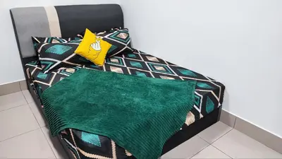 a bed with a green blanket and pillows on it at YOLO Budget Condo KL 5.0 in Kuala Lumpur