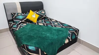 a bed with a green blanket and pillows on it at YOLO Budget Condo KL 5.0 in Kuala Lumpur
