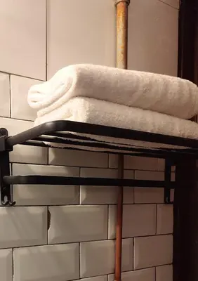 a stack of towels on a towel rack in a bathroom at Bestow Boutique Hotel in Kuala Lumpur