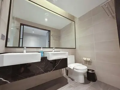 a bathroom with a sink and a toilet and a mirror at M101 KLCC KL city King Suites by Livin in Kuala Lumpur