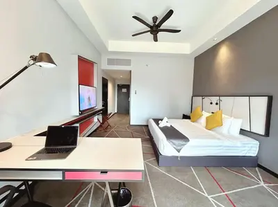 a bedroom with a bed and a desk with a laptop at M101 KLCC KL city King Suites by Livin in Kuala Lumpur