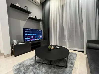 a living room with a black table and a tv at Lucentia Residence At Kuala Lumpur By Dreamcloud in Kuala Lumpur