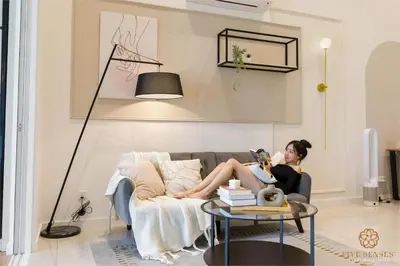 a woman sitting on a couch in a living room at Quill Residences Kuala Lumpur, Five Senses in Kuala Lumpur