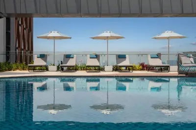 a swimming pool with chairs and umbrellas on a building at Crowne Plaza Kuala Lumpur City Centre by IHG in Kuala Lumpur