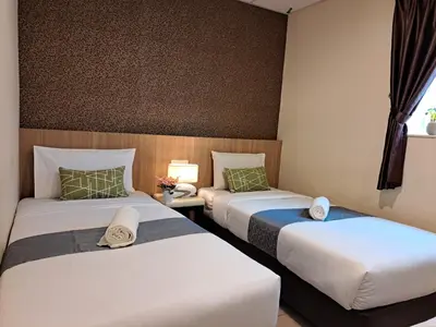 a hotel room with two beds and a window at SCC Gateway Chinatown Hotel in Kuala Lumpur
