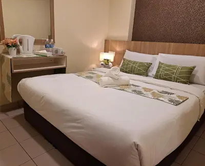 a bedroom with a large bed with a towel on it at SCC Gateway Chinatown Hotel in Kuala Lumpur