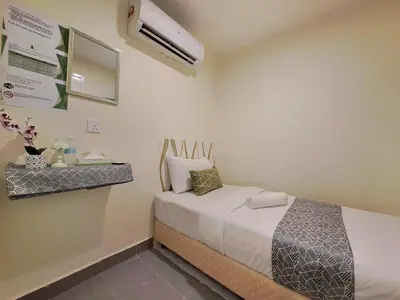 a small bedroom with a bed and a air conditioner at SCC Gateway Chinatown Hotel in Kuala Lumpur