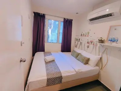 a small bedroom with a bed with purple curtains at SCC Gateway Chinatown Hotel in Kuala Lumpur