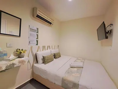 a small bedroom with a bed and a tv at SCC Gateway Chinatown Hotel in Kuala Lumpur