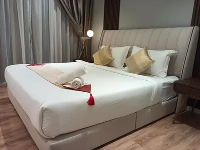 a large white bed with a red ribbon on it at Quill Residence KLCC in Kuala Lumpur