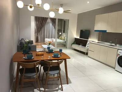 a kitchen and living room with a wooden table and chairs at Quill Residence KLCC in Kuala Lumpur