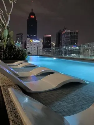 a pool on the roof of a building with a city skyline at Quill Residence KLCC in Kuala Lumpur