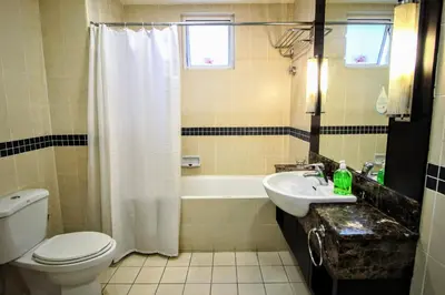 a bathroom with a toilet and a sink and a tub at Electus Suite in Kuala Lumpur