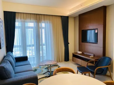 a living room with a blue couch and a television at Tribeca Serviced Hotel by Millennium in Kuala Lumpur