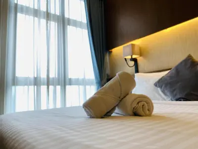 a towel animal laying on a bed in a hotel room at Tribeca Serviced Hotel by Millennium in Kuala Lumpur