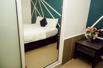 a mirror in a small room with a bed at V Hotel Titiwangsa in Kuala Lumpur