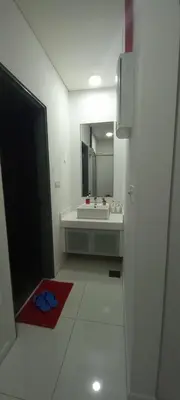 a white bathroom with a sink and a mirror at COZY TWO BEDROOM APARTMENT AT MERCU SUMMER in Kuala Lumpur