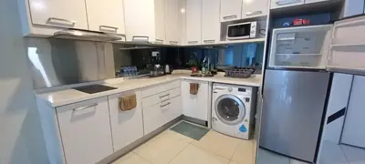 a kitchen with white cabinets and a washer and dryer at COZY TWO BEDROOM APARTMENT AT MERCU SUMMER in Kuala Lumpur