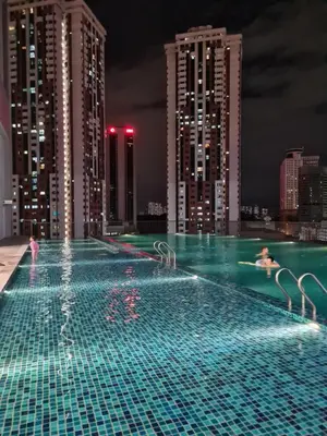 a swimming pool on top of a city at night at Chambers Service Suites KLCC By Cozy Stay in Kuala Lumpur