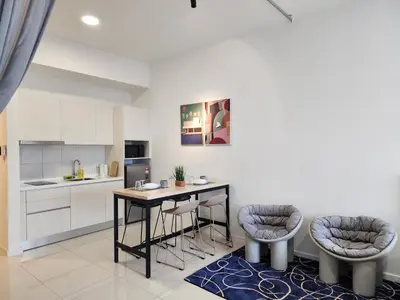 a kitchen with a table and two bar stools at Chambers Suites KL BY Fortune in Kuala Lumpur